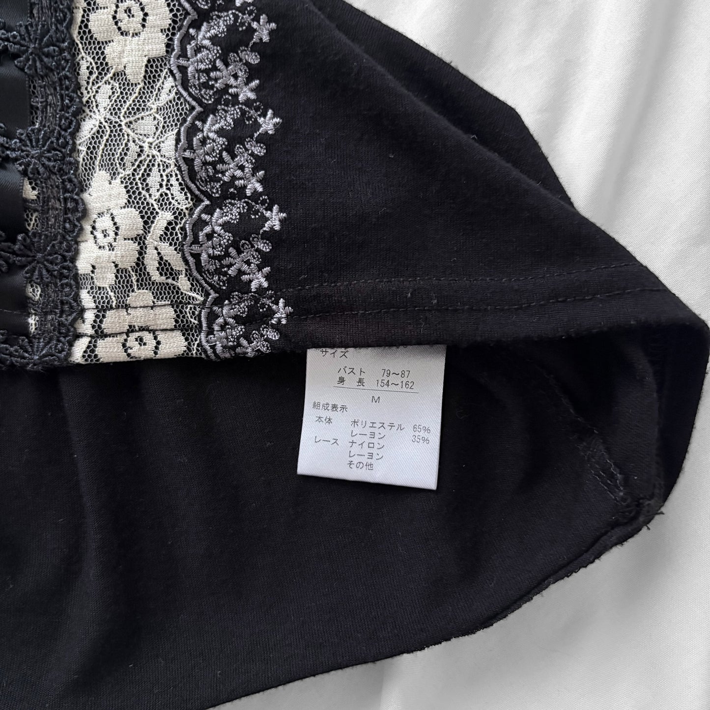 ‘Axes Femme’ Black Top with White Lace Details